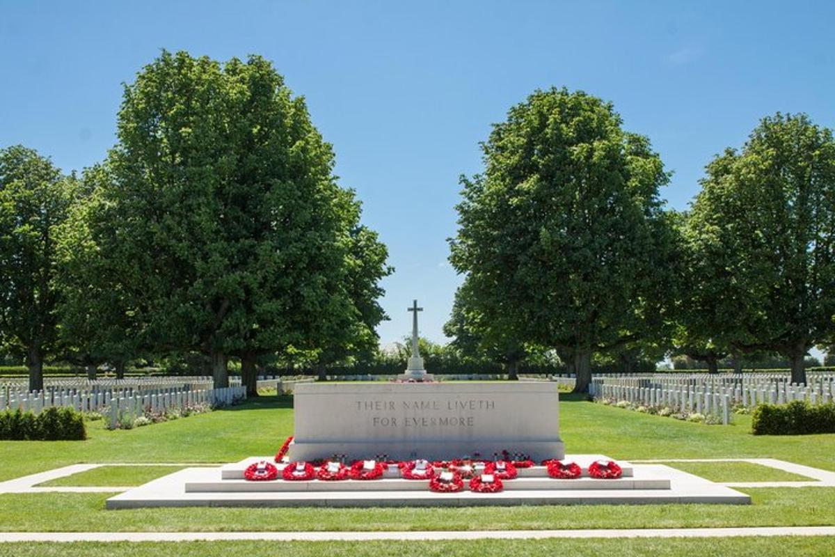 um monumento em um cemitério com flores vermelhas