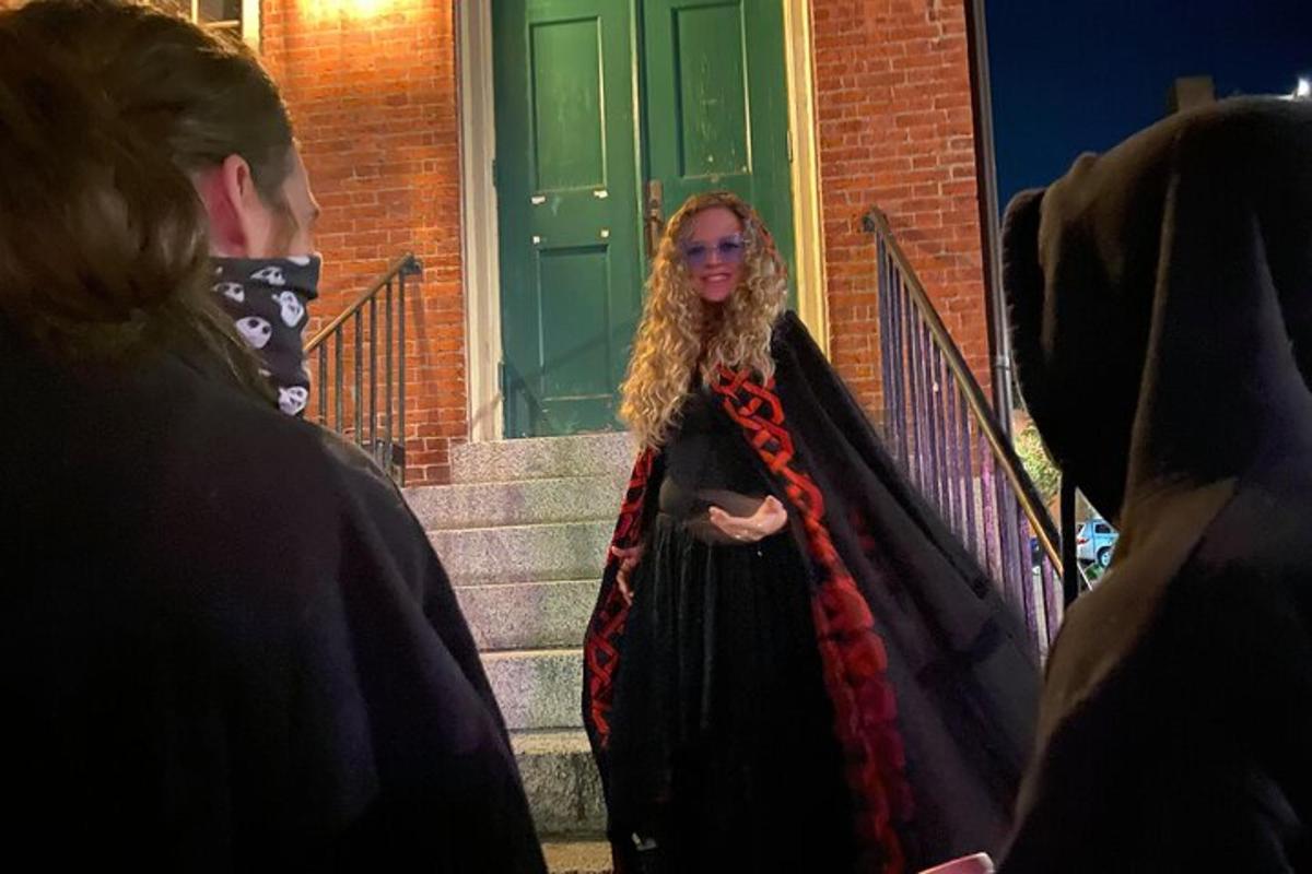 a woman in a cape walking down the stairs