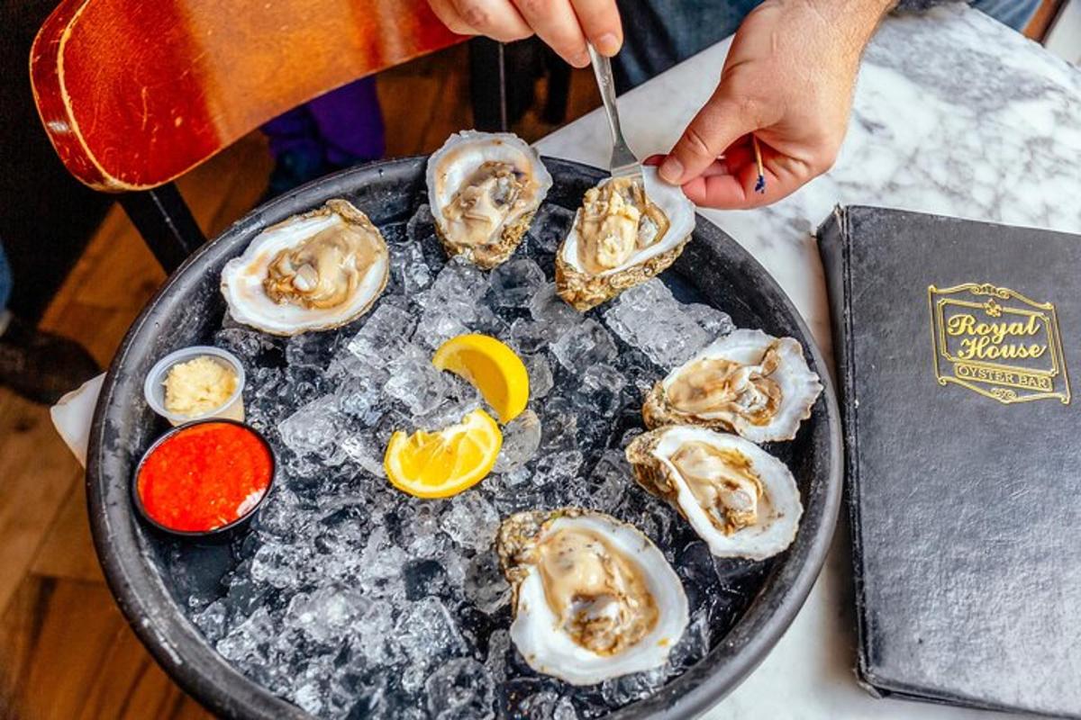 a plate of oysters on a table with a person holding a knife