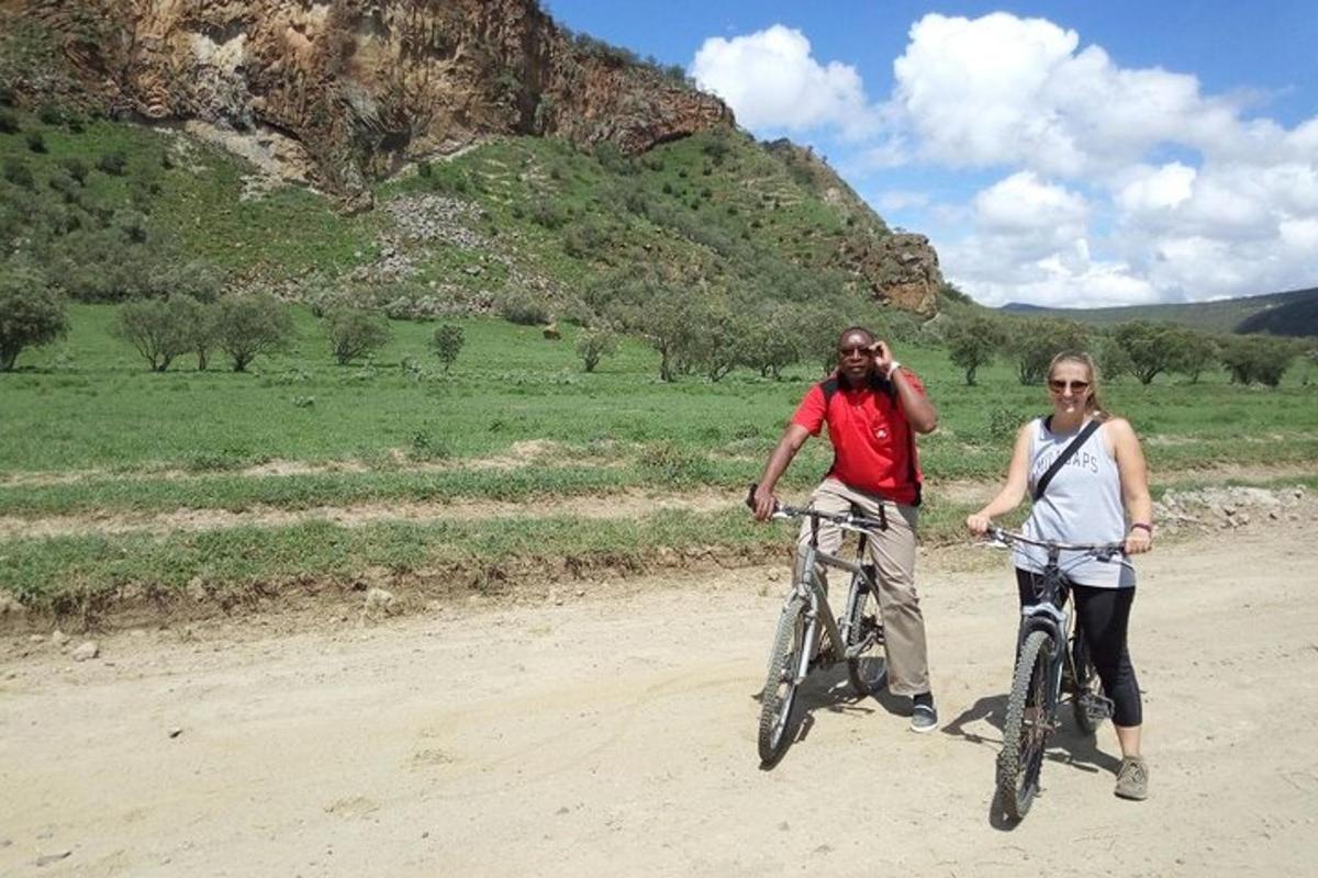 Un hombre y una mujer andan en bicicleta por un camino de tierra.