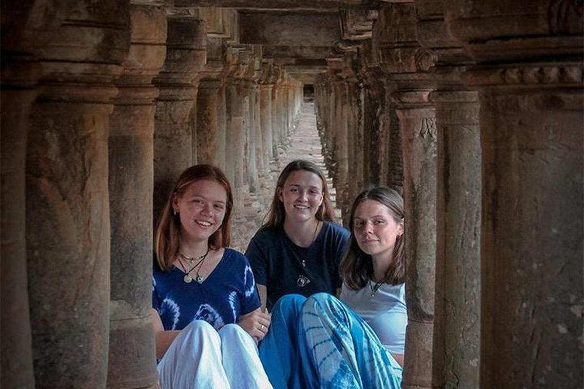 tre ragazze sedute in una fila di colonne
