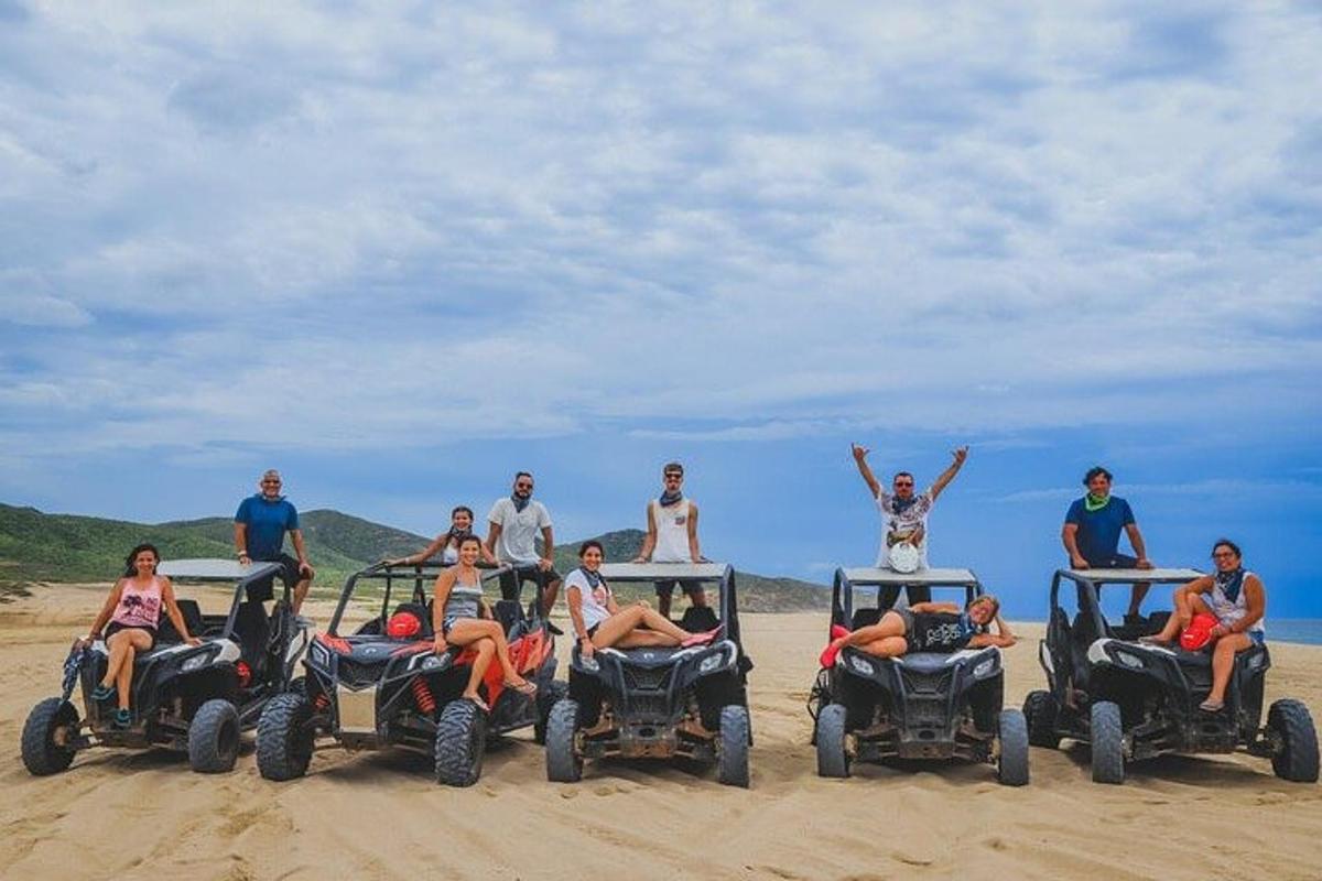 a group of people sitting on four wheelers on the beach
