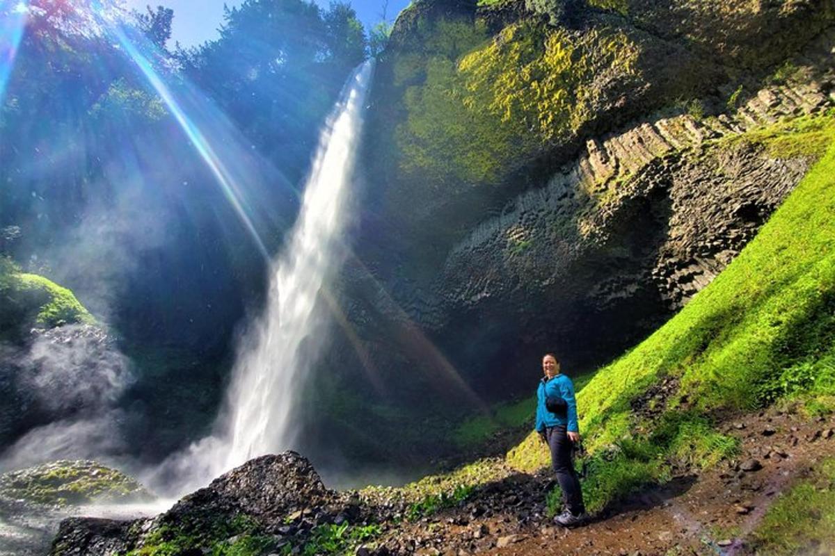 a man standing in front of a waterfall