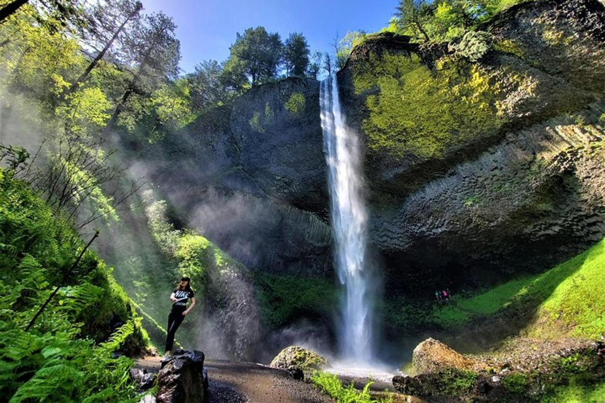 a woman standing in front of a waterfall
