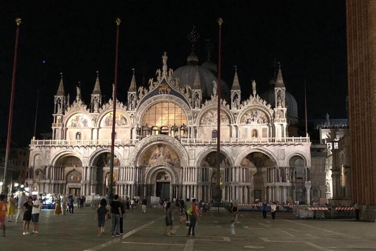 un gran edifici amb gent dreta davant seu a la nit