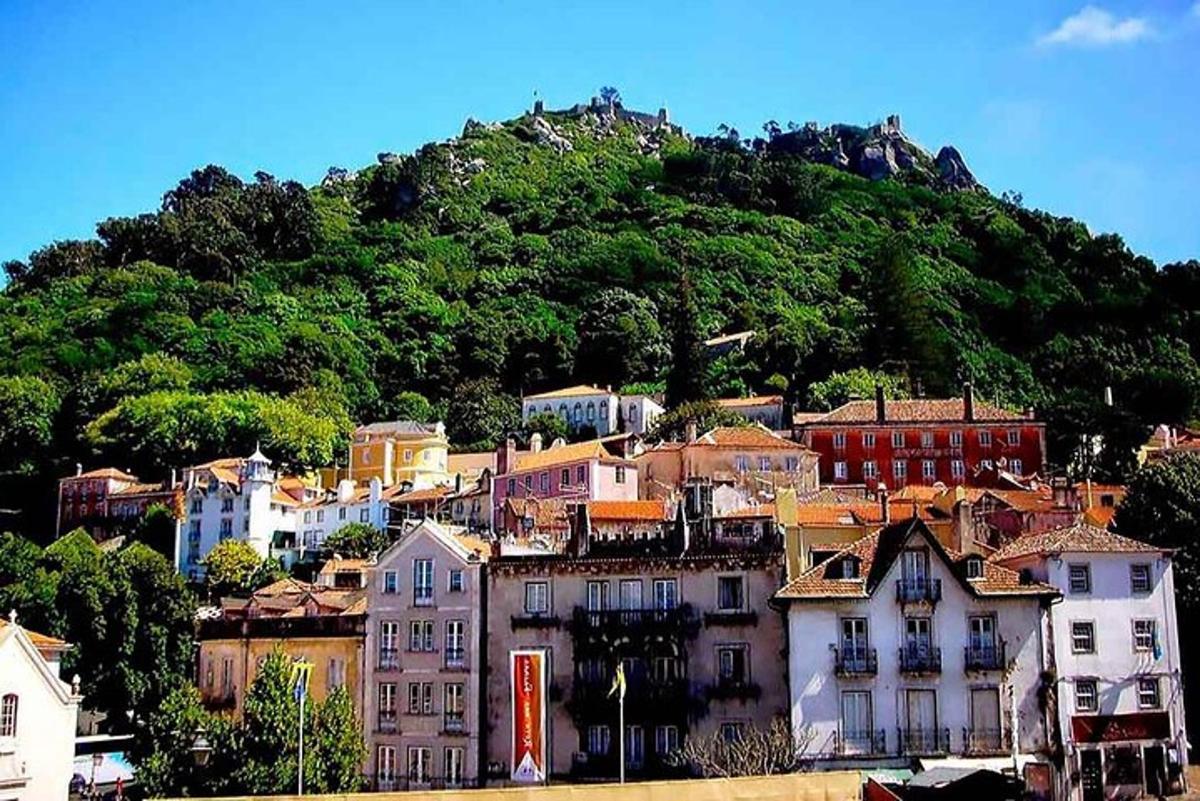 a town on a hill with a mountain in the background