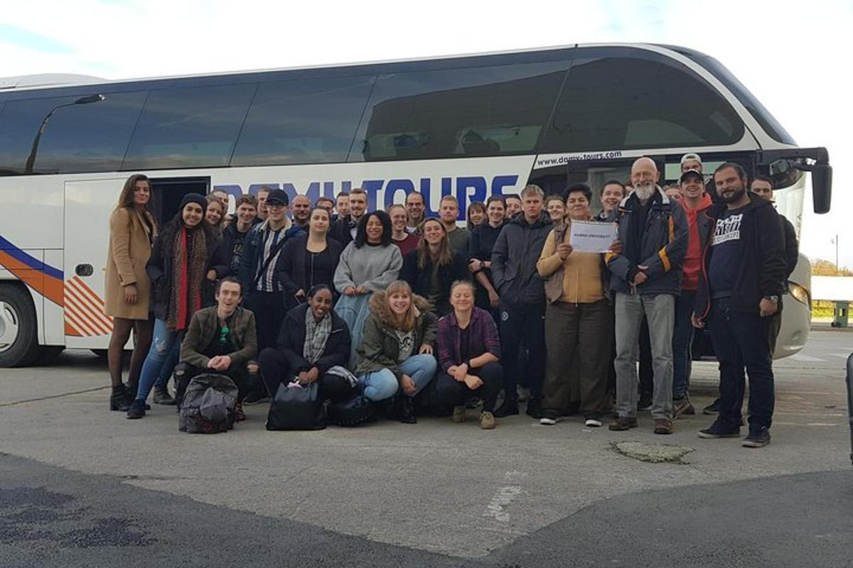 bir otobüsün önünde duran bir grup insan