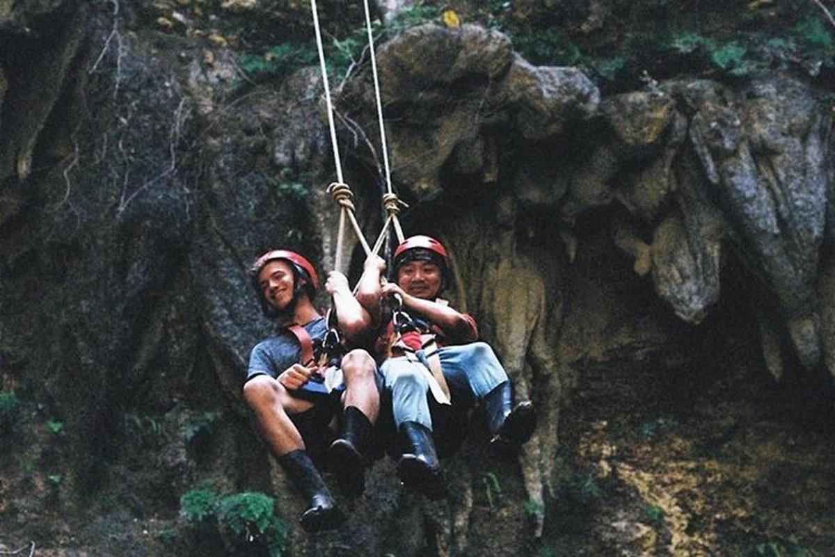dos homes asseguts en un gronxador de corda