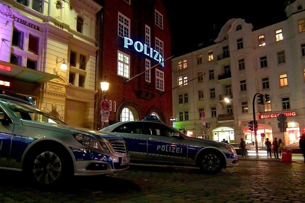 policijos automobilis, pastatytas miesto gatvėje naktį