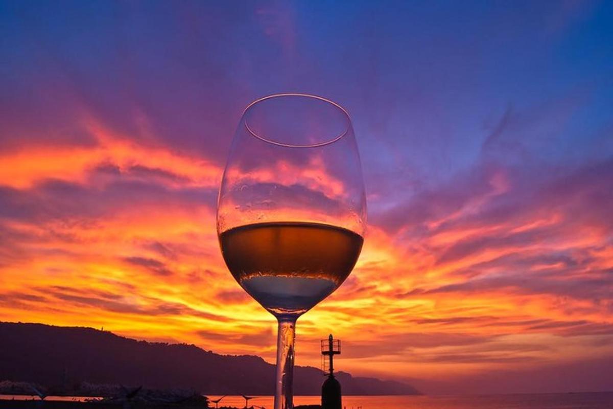 a glass of wine with the sunset in the background