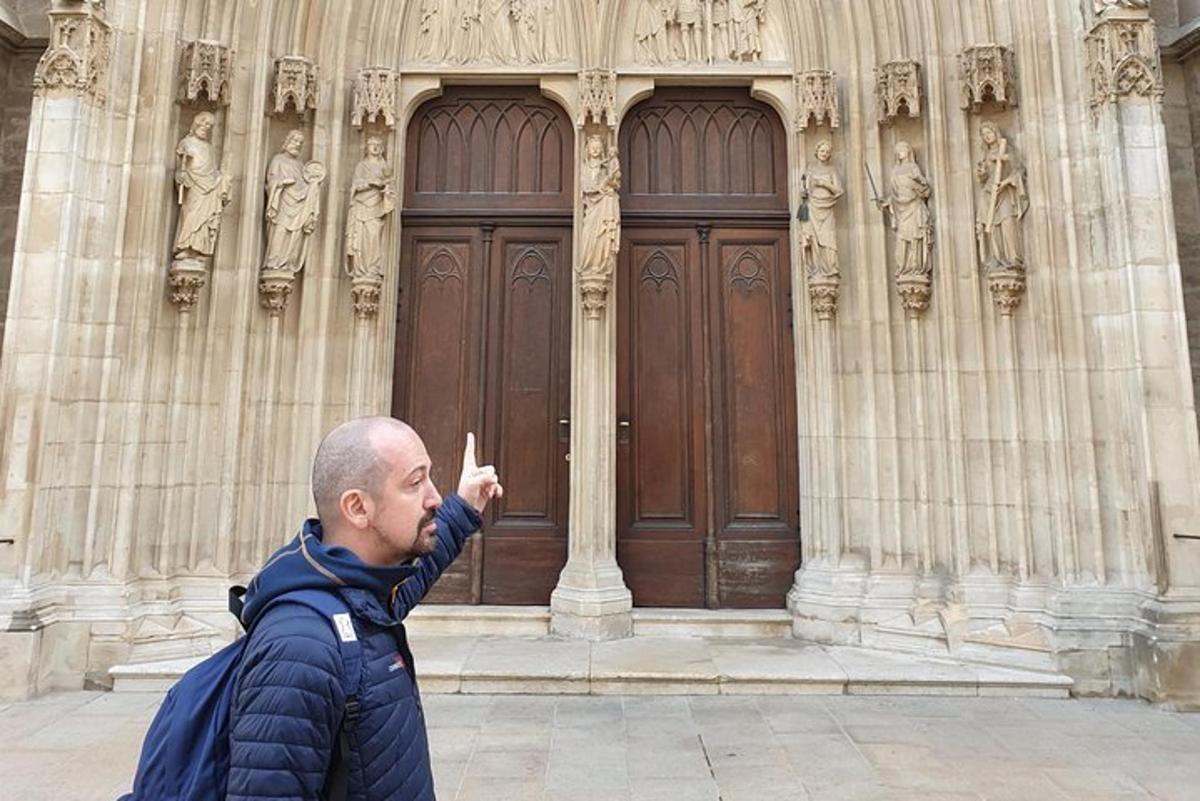 un home amb jaqueta blava assenyalant un edifici