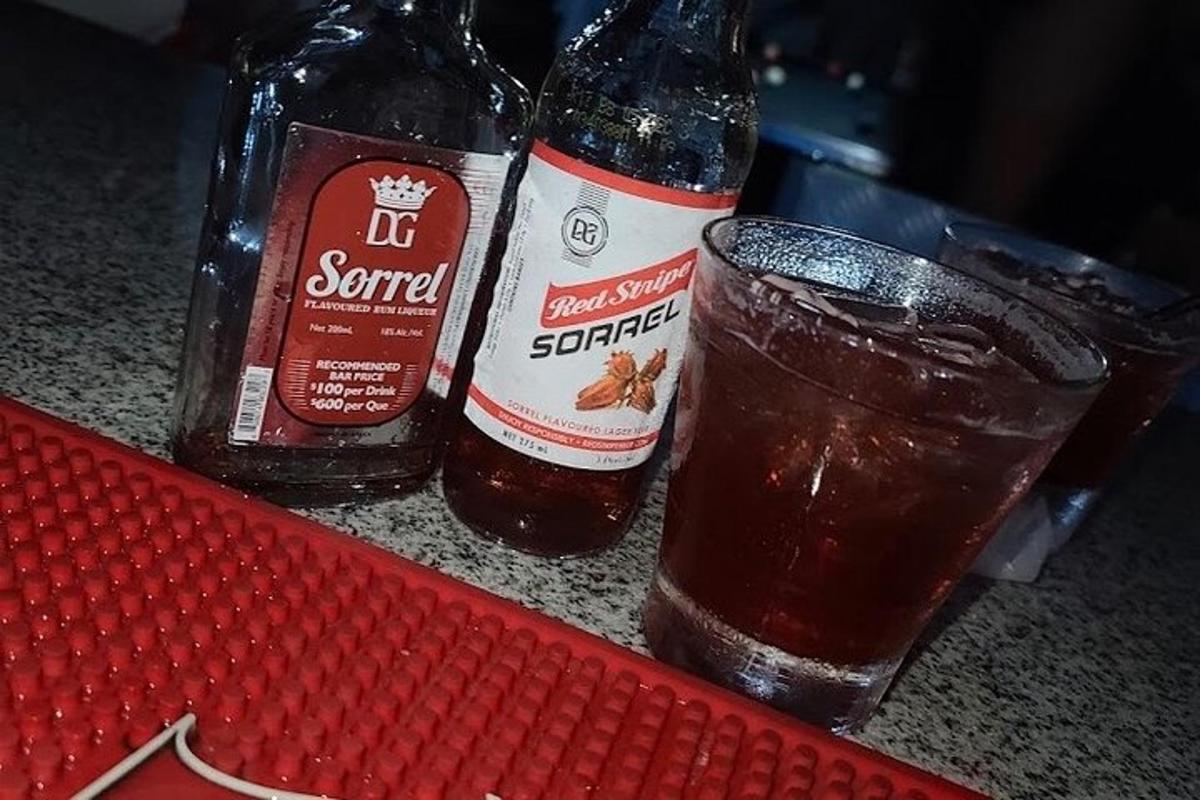 two bottles of beer sitting on a counter with a glass