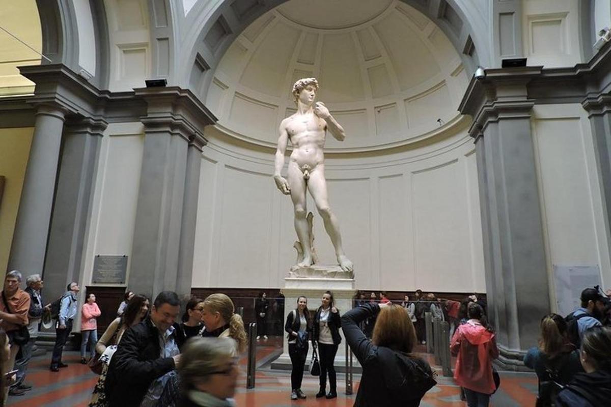 un gruppo di persone in piedi attorno a una statua in un museo