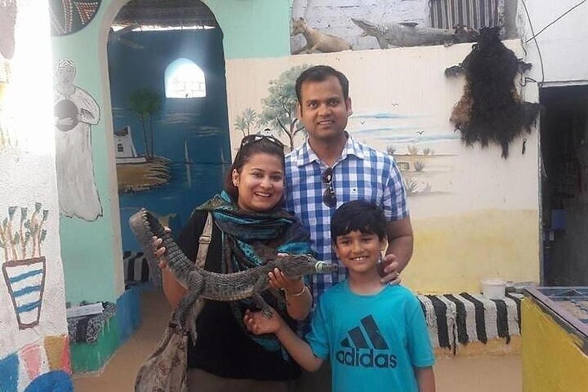 a man and two children are holding a snake