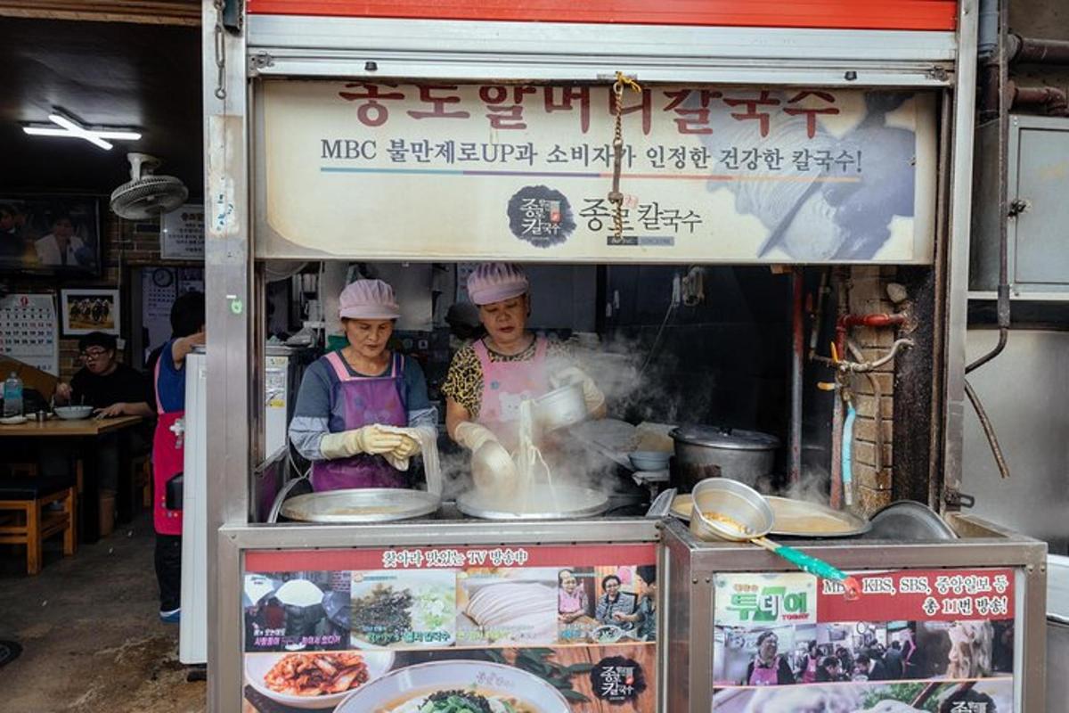 Dos chefs preparando comida en un carrito de comida.