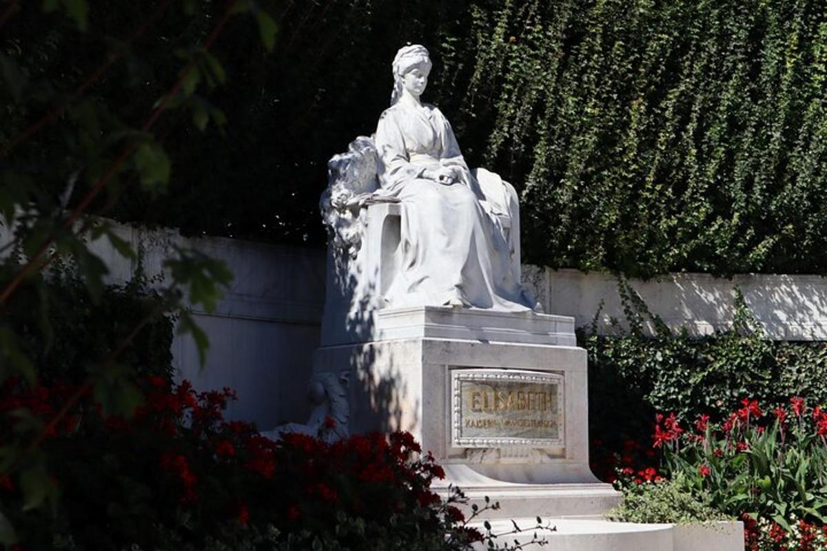 una statua di una donna seduta in un giardino