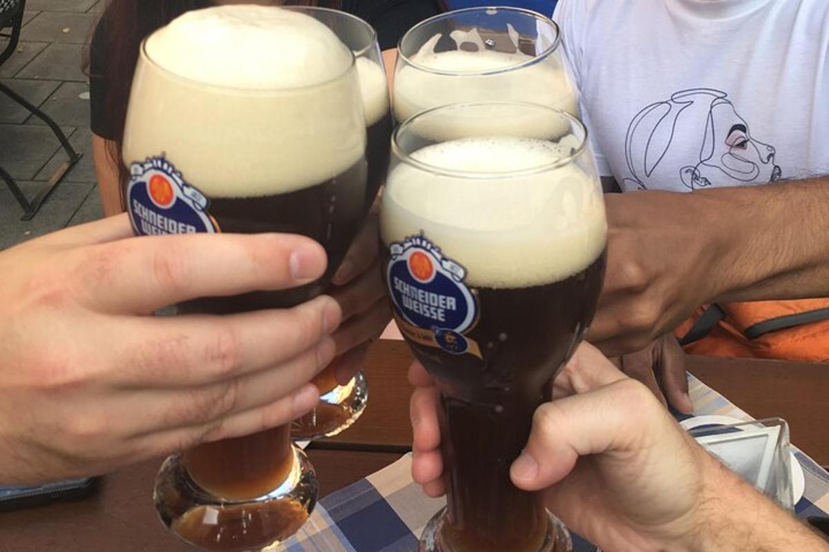 due persone stanno tenendo in mano dei bicchieri di birra