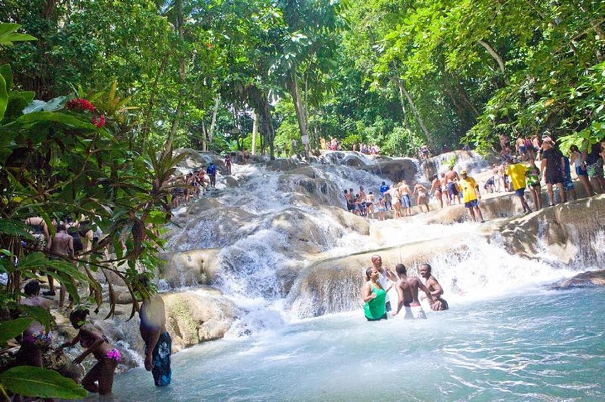 um grupo de pessoas em pé na água de uma cachoeira