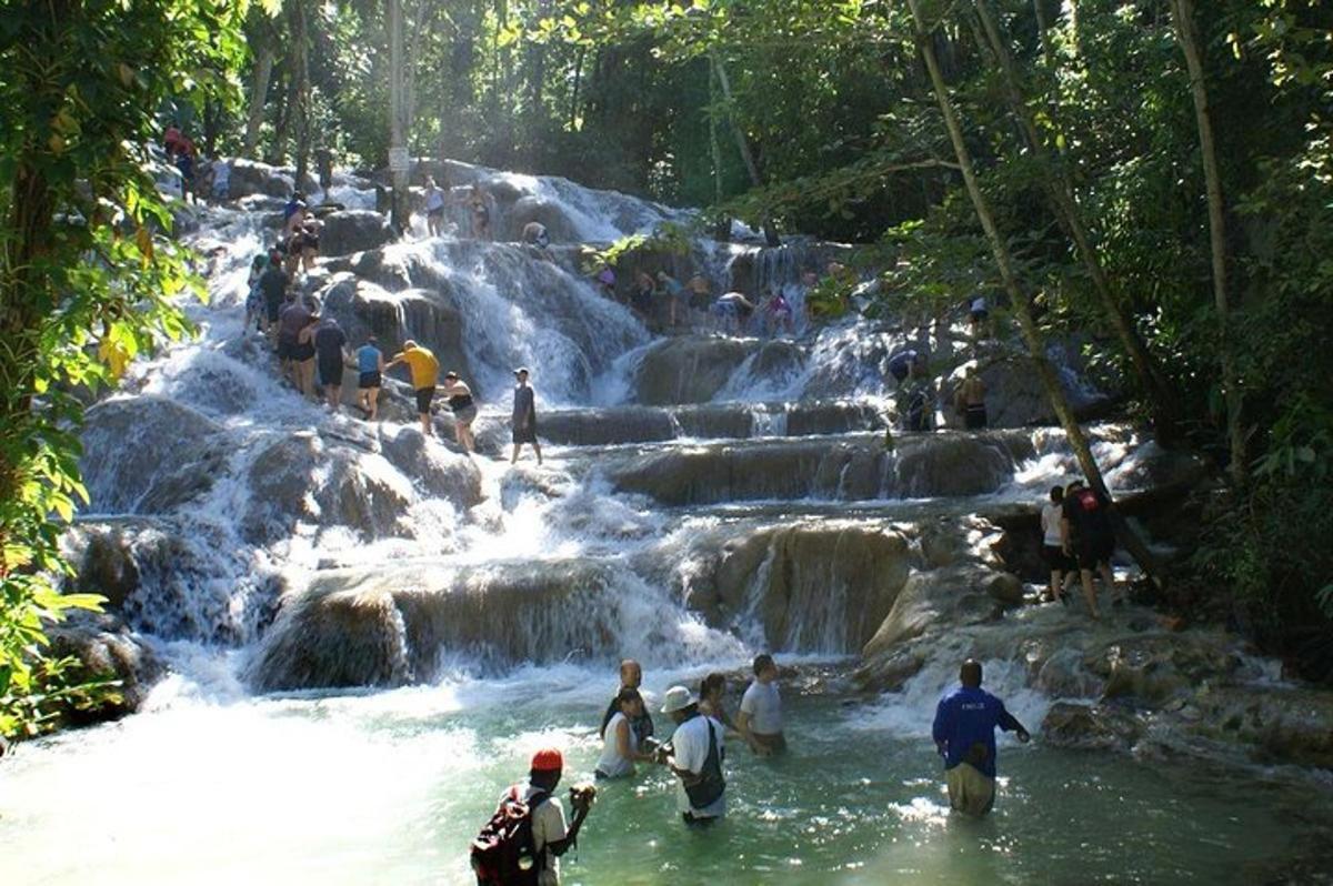 um grupo de pessoas em pé em uma cachoeira