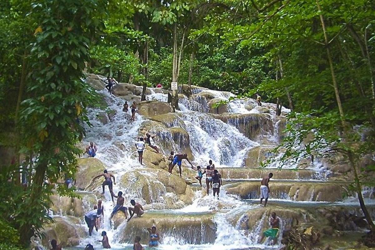 um grupo de pessoas em pé sobre as rochas de uma cachoeira