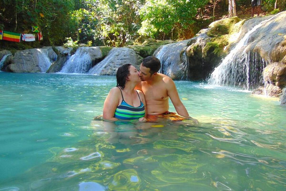 un home i una dona a l'aigua davant d'una cascada