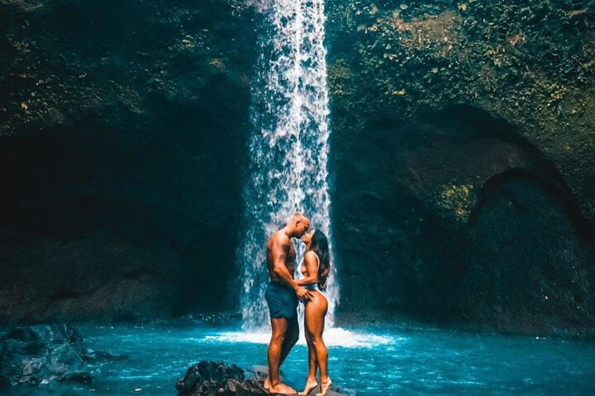 a couple standing in front of a waterfall