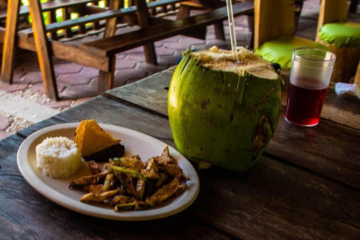 a plate of food on a table next to a large pineapple