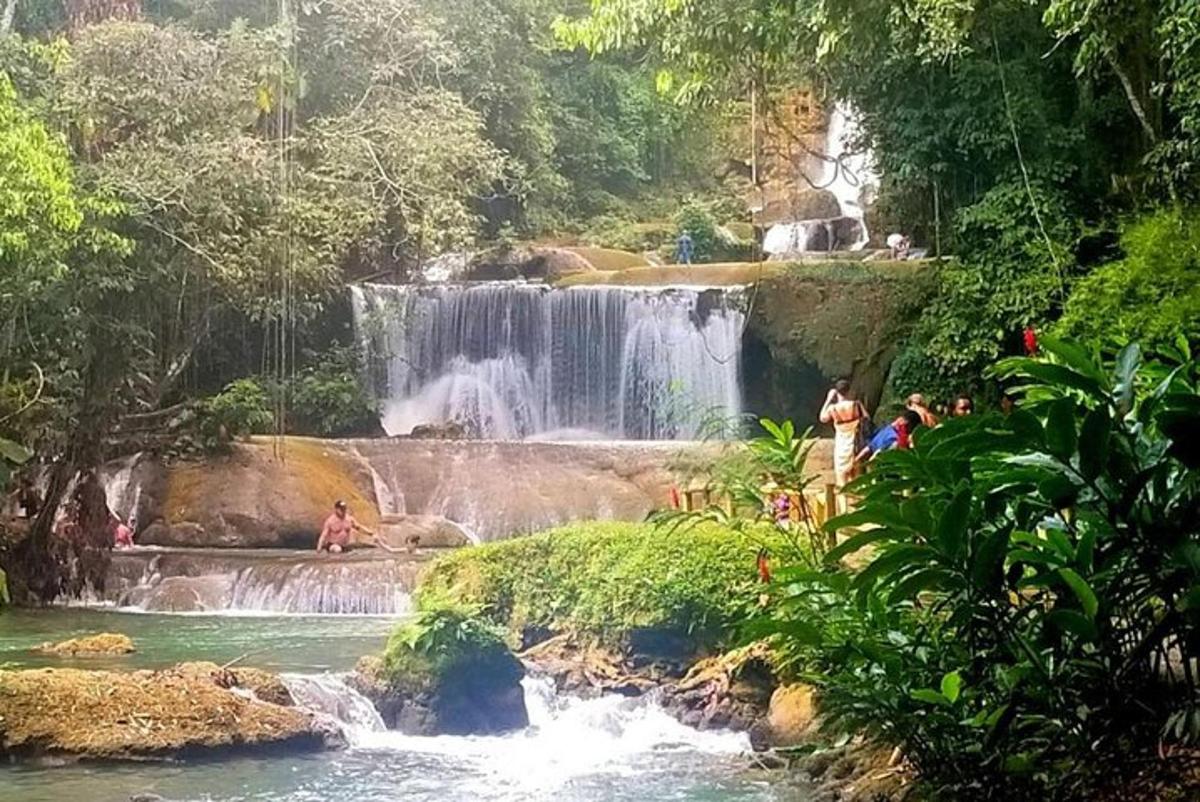 una cascata in mezzo a un fiume con persone dentro