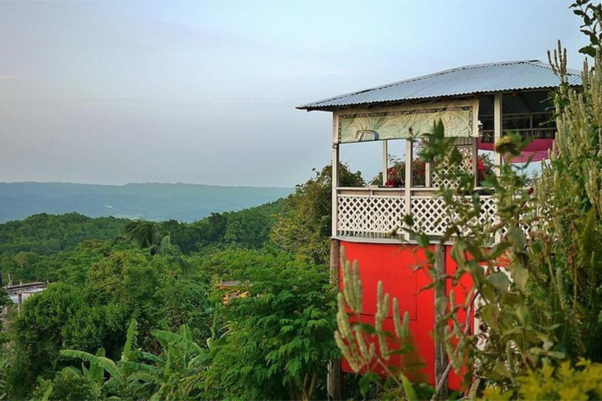 un edificio rosso con un balcone in cima a una collina