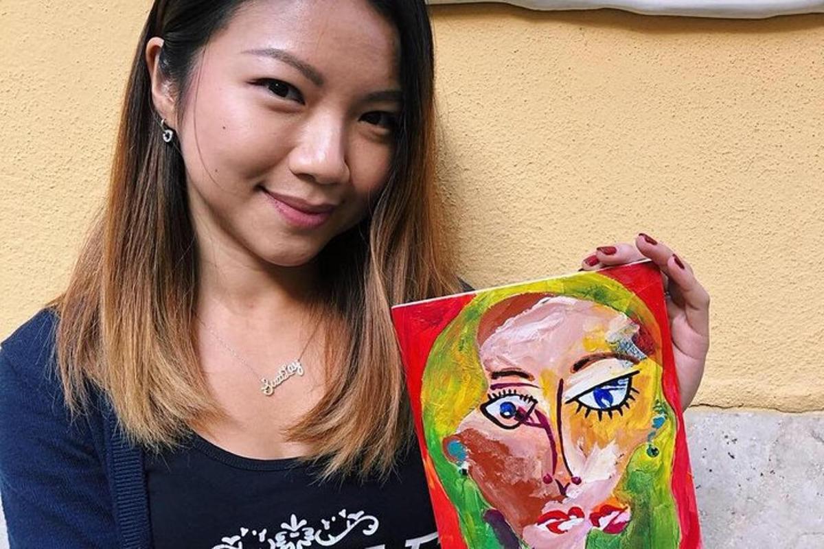 a woman holding up a painting of a woman