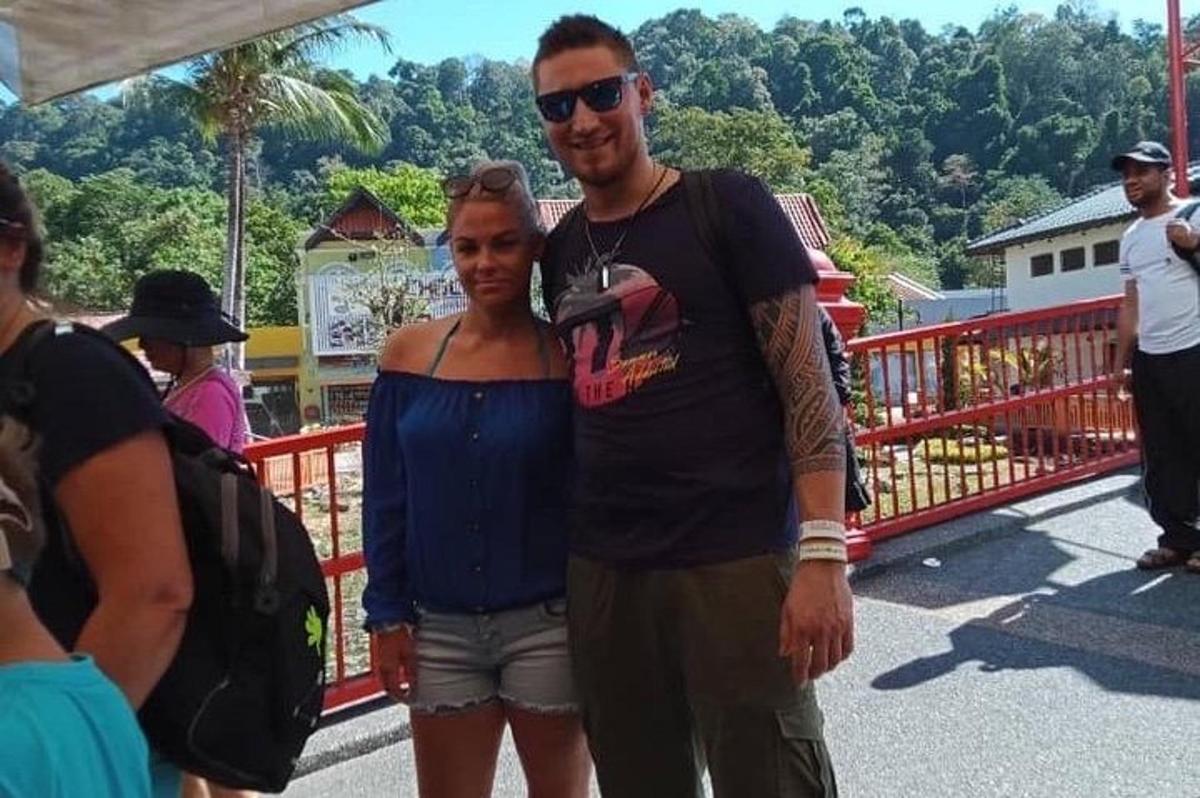 moški in ženska stojita na mostu