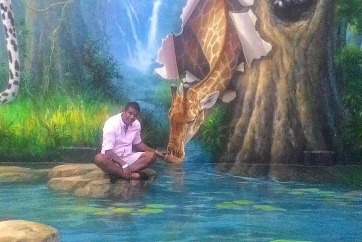 un uomo inginocchiato davanti a un dipinto di una giraffa