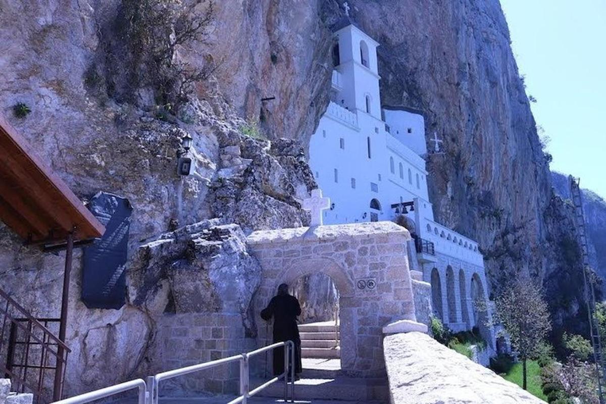 a man walking up a staircase to a building on a mountain