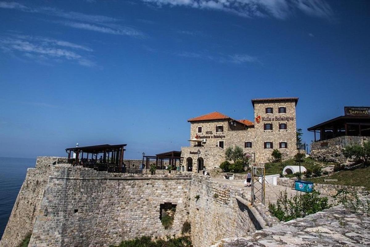 Un edificio encima de un muro de piedra junto al océano.