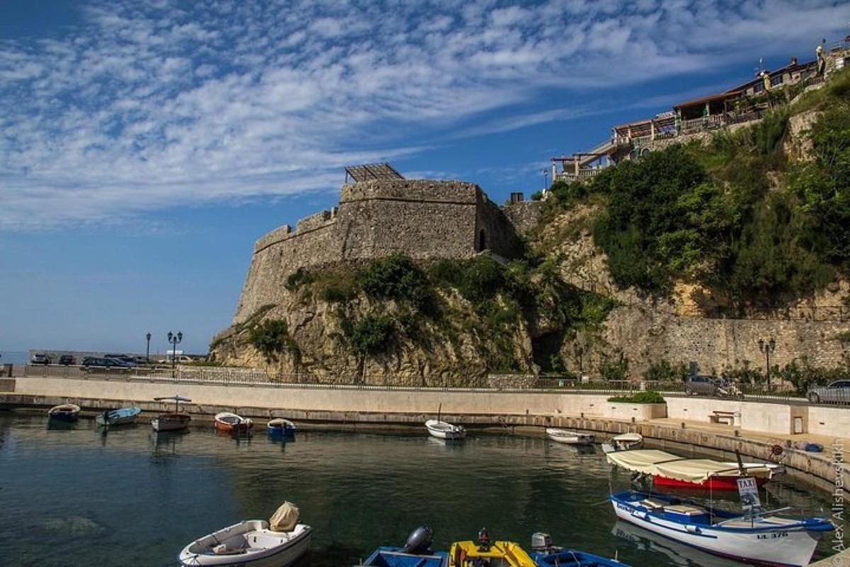 Un grupo de barcos en el agua cerca de un castillo.