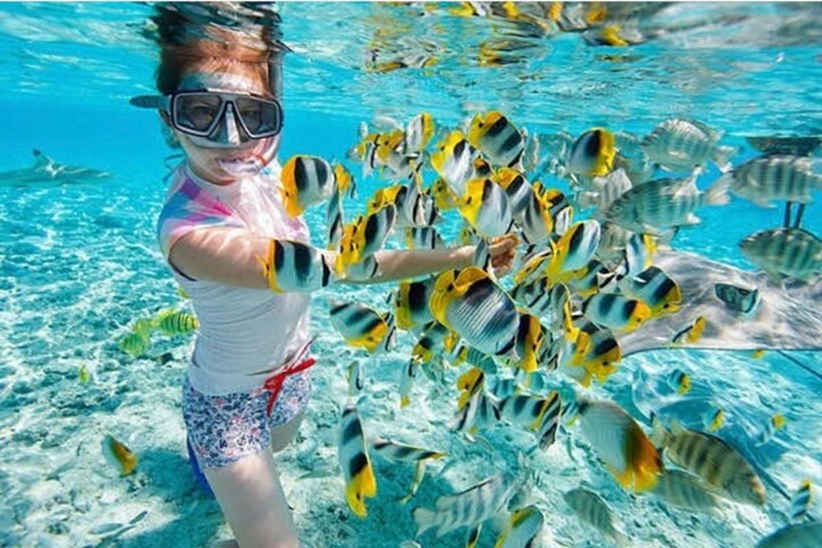 una donna in acqua con un mucchio di pesci