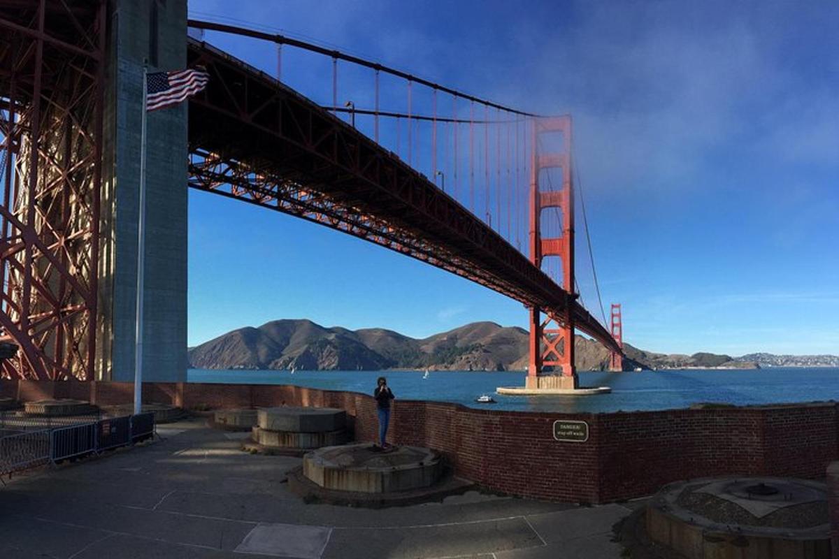 oseba, ki stoji pod mostom Golden Gate