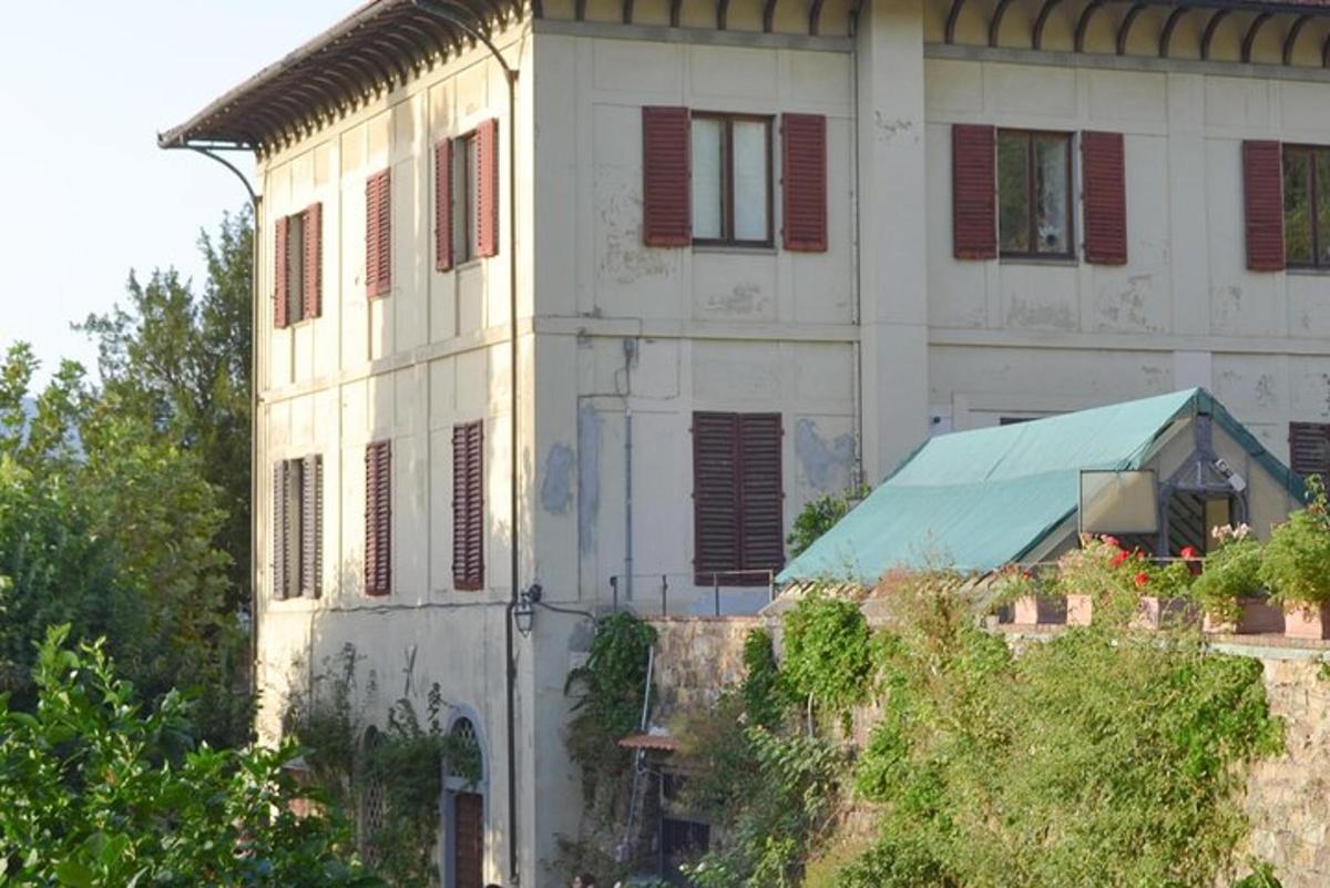 un vecchio edificio bianco con le persiane rosse