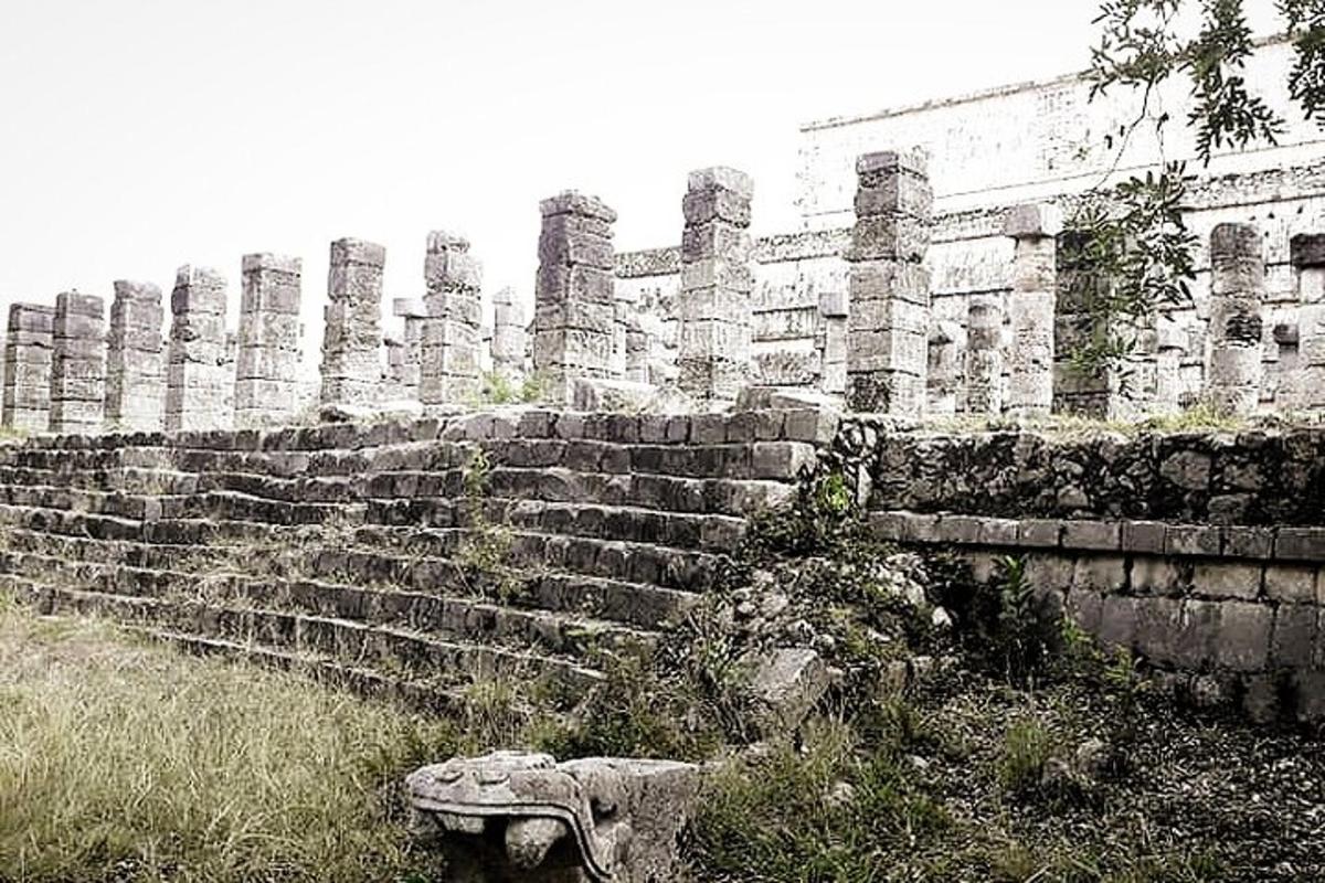 an old stone wall with a bench in front of it