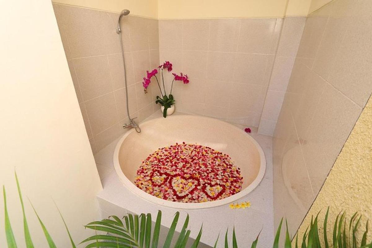một bồn tắm đầy những hạt rắc màu hồng trong phòng tắm