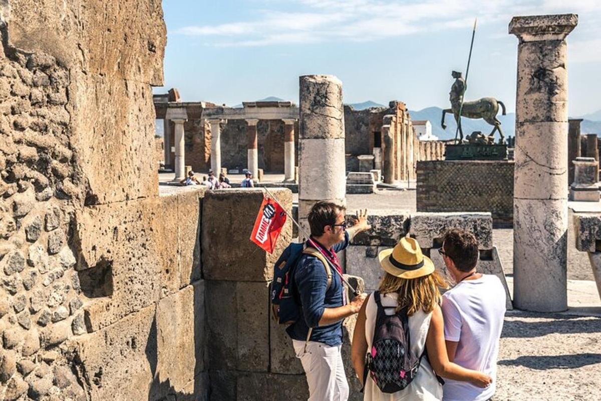 un groupe de personnes debout devant les ruines