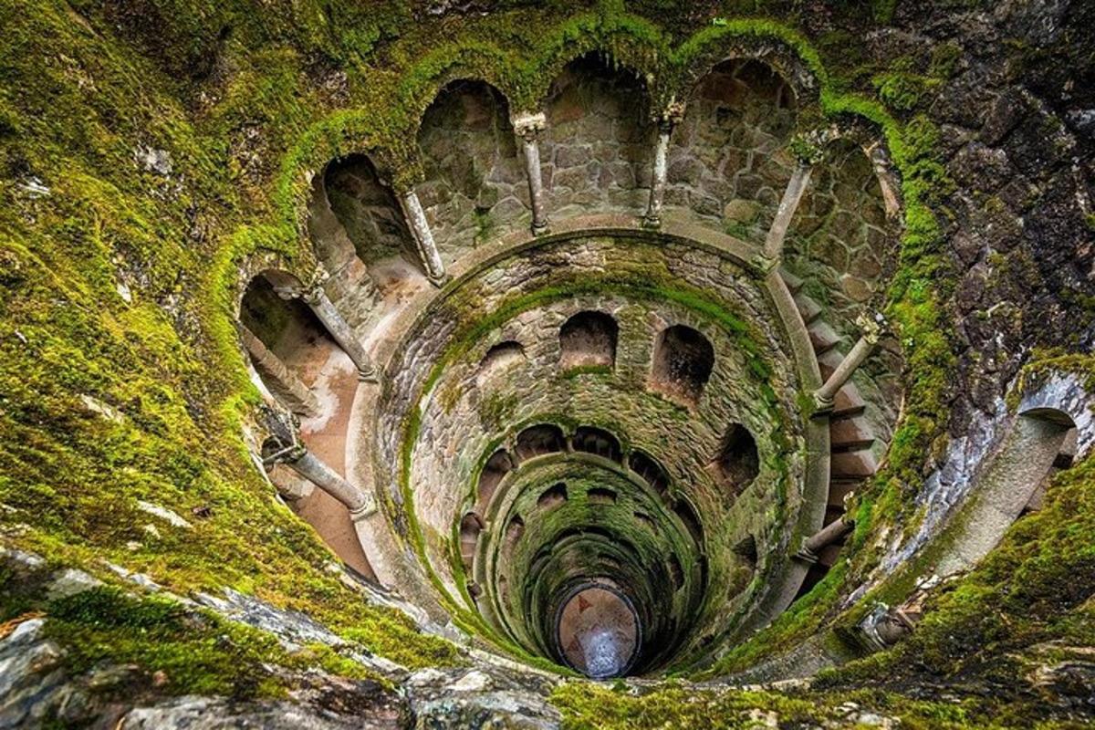 an old tunnel with moss on the side of a mountain