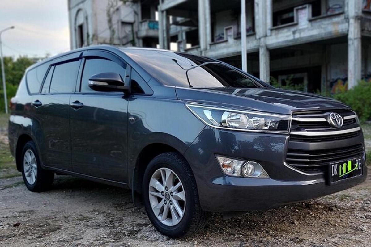 um carro azul estacionado em frente a um prédio