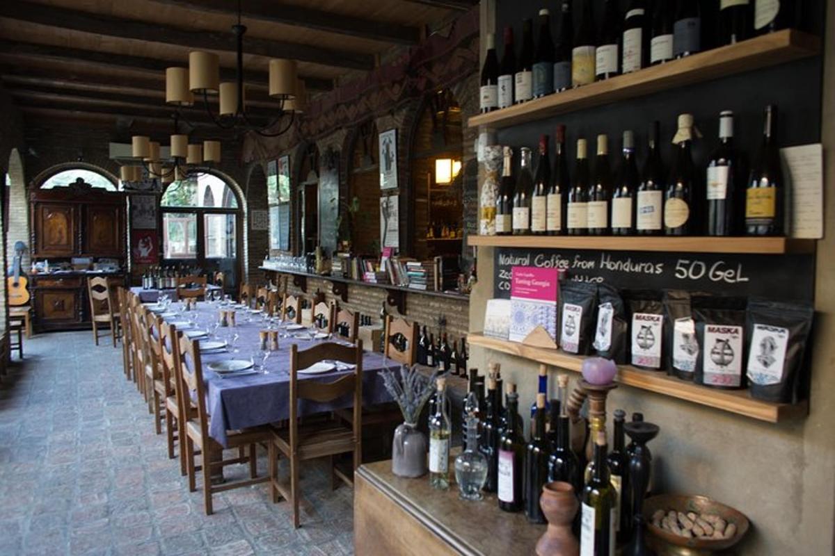 restavracija z dolgo mizo in steklenicami vina
