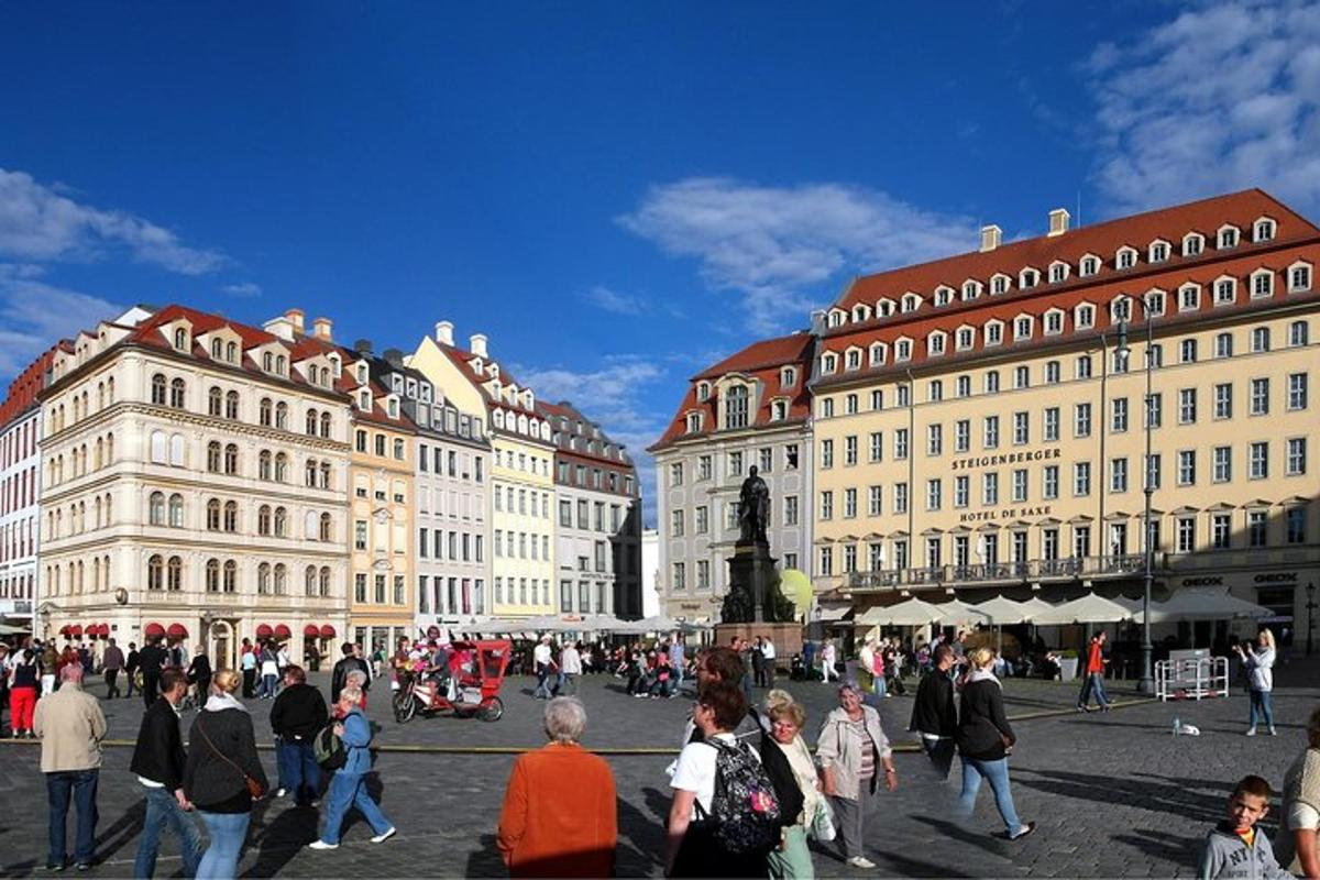 grupp inimesi, kes jalutavad mööda linna, kus on palju hooneid