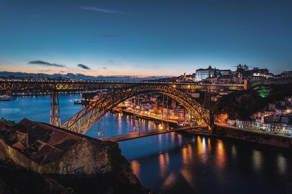 uma ponte sobre um rio com uma cidade à noite