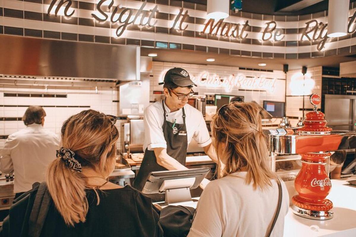 muž připravující jídlo v restauraci se dvěma ženami