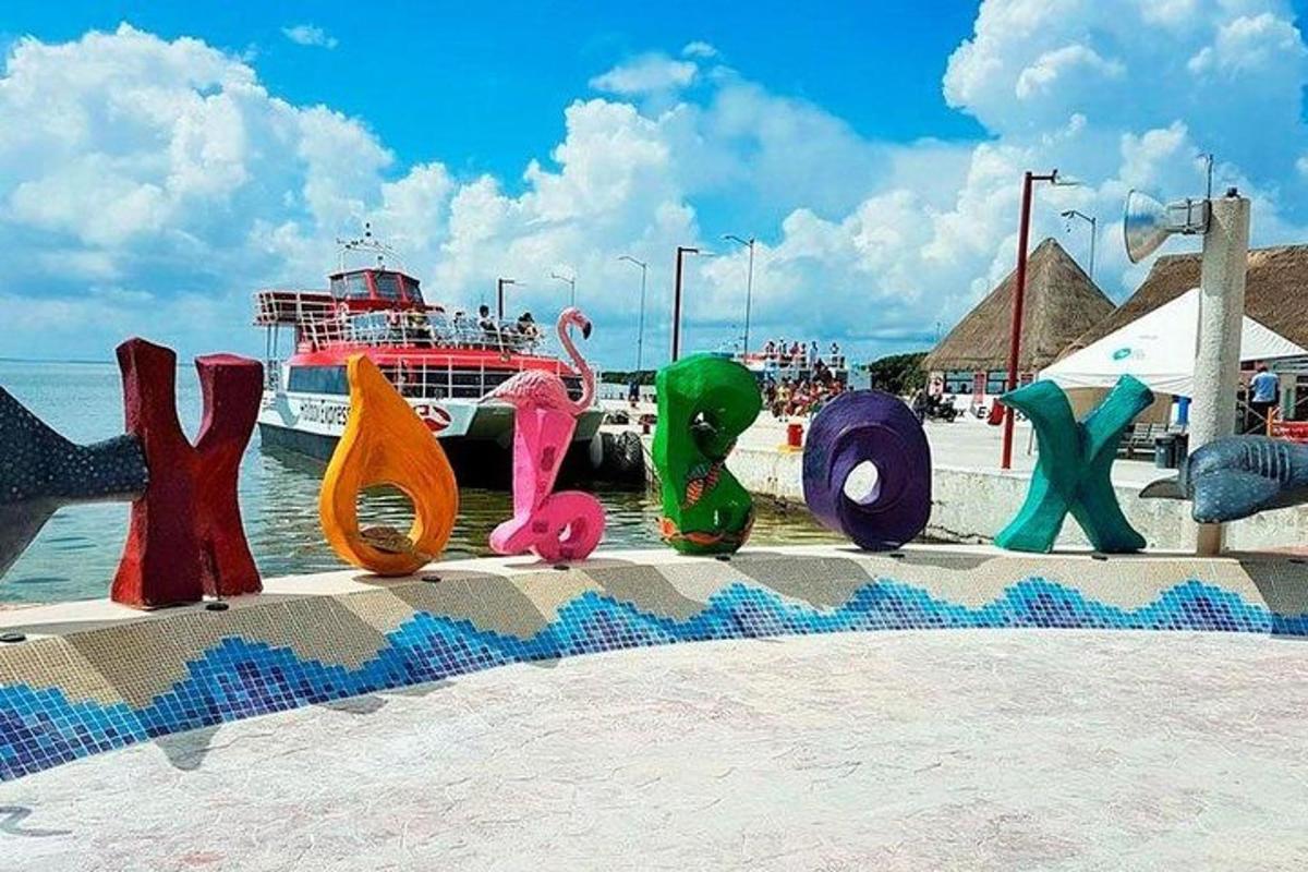 un gruppo di sculture colorate su una spiaggia con una nave da crociera