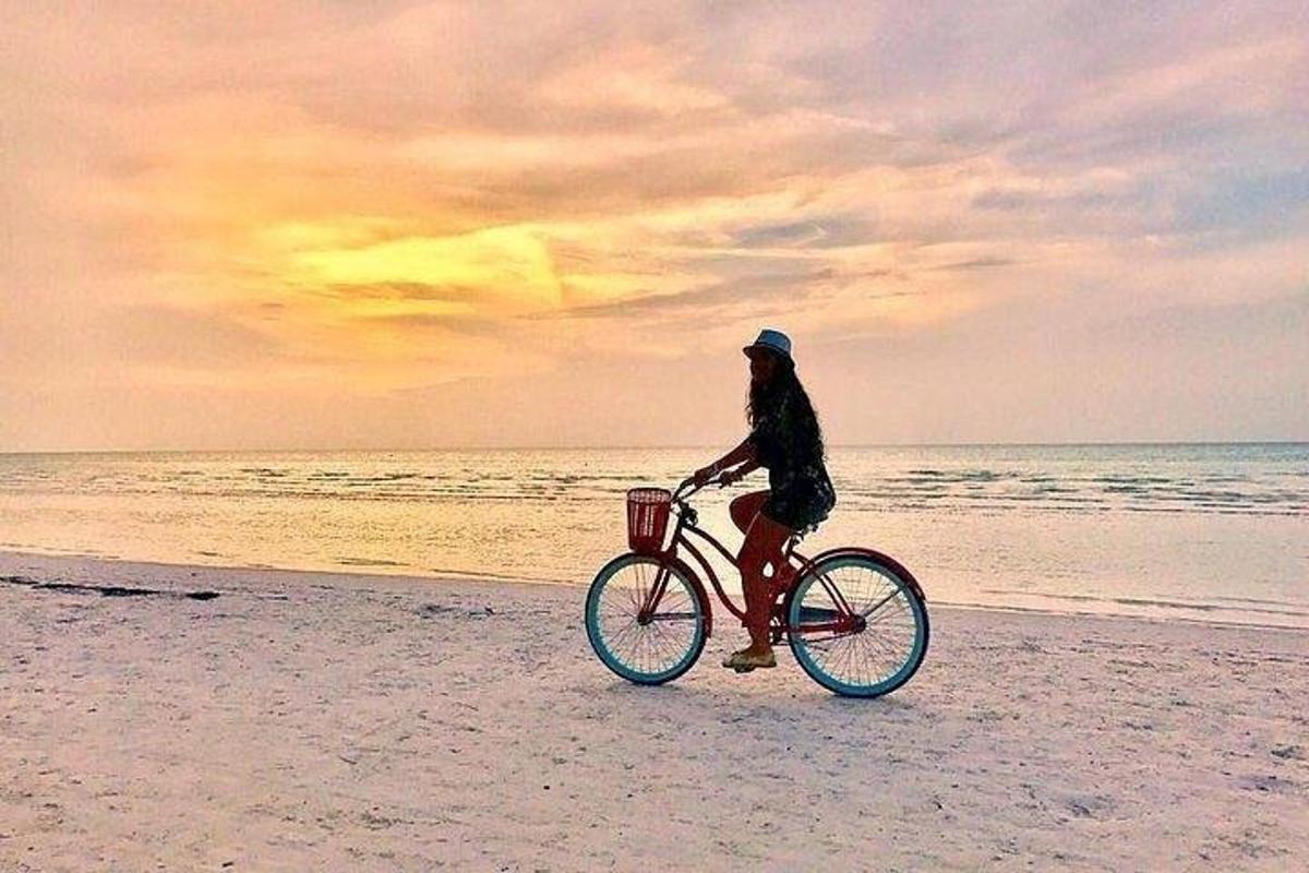 en person som sykler på stranden