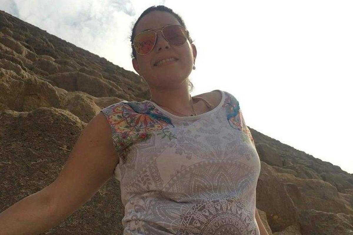 päikeseprille kandev naine seisab kivide kõrval